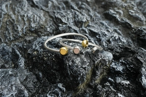 Détails de bracelets torsadés de style câble sur un support en pierre texturée