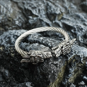 Bracelet jonc dragon vintage en argent avec câble d'acier torsadé sur fond de roche sombre