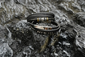 Détail de bracelets en cuir tressé avec fermoirs magnétiques polis sur roche sombre