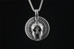 Macro view of vintage Spartan helmet round pendant with Greek meander borders in steel