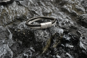 Close-up of men's double-layer braided leather bracelet with magnetic brushed steel clasp
