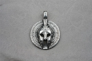 Macro shot of silver spartan helmet pendant with Greek fret pattern and vintage finish