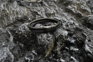Close-up of black braided leather men's bracelet with a brushed metal magnetic clasp