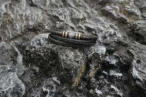 Détail d'un bracelet multicouche en cuir tressé avec des perles rétro sur roche