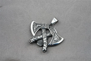Détail du pendentif double hache Viking avec relief de créature mythique et acier poli