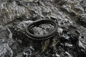Detail of double-layer black braided leather bracelet for men with magnetic metal clasp