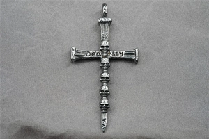 Macro view of gothic cross pendant featuring five skull carvings and Deathly engraving