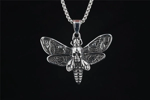 Gros plan du pendentif papillon crâne gothique avec finition oxydée et chaîne