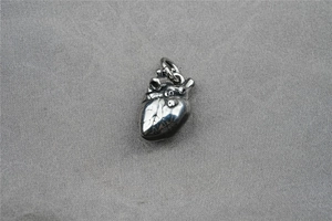Makroaufnahme des anatomischen Herzanhängers mit antikem Silberfinish und feiner Textur