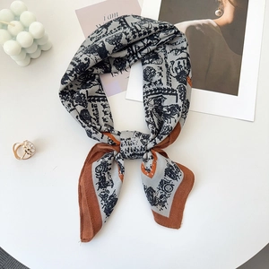 Close-up of vintage carriage pattern silk square scarf with orange rolled edge detail