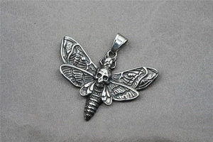 Vue détaillée du pendentif papillon et crâne gothique avec finition acier vieilli