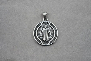 Macro shot of vintage Saint Benedict relief on titanium steel religious pendant necklace