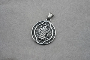 Macro view of vintage Saint Benedict medal pendant in silver steel with relief detailing