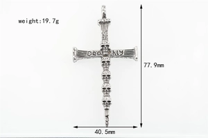 Detailed macro view of punk retro cross pendant with five carved skulls and Deathly engraving