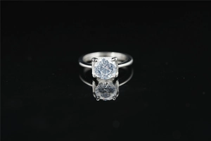 Dettaglio di un classico anello solitario in moissanite con montatura a quattro griffe e riflessi