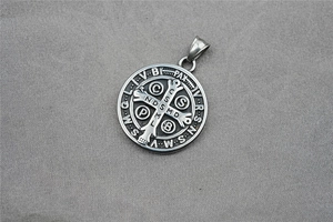 Macro shot of vintage Saint Benedict Medal pendant in stainless steel with oxidized details