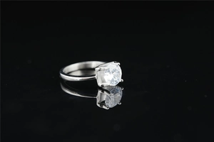 Dettaglio dell'anello con moissanite a taglio rotondo e montatura a quattro griffe in acciaio