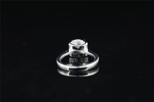 Vista macro laterale di un anello con moissanite rotonda e castone alto color argento