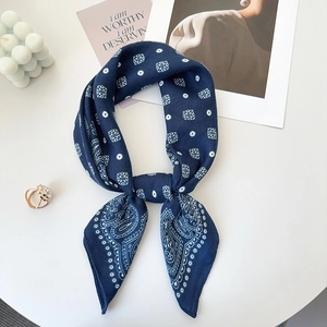 Detail of navy blue bandana with paisley and polka dot prints tied in a knot