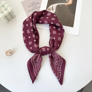 Close-up of burgundy paisley silk scarf with geometric pattern and smooth texture