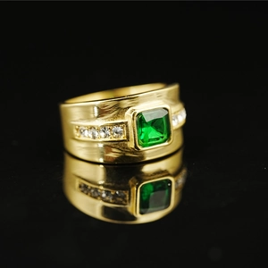 Men's gold plated titanium ring featuring a square green emerald and side accent diamonds