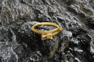 Detailed macro view of a vintage golden dragon head bangle with twisted cable texture