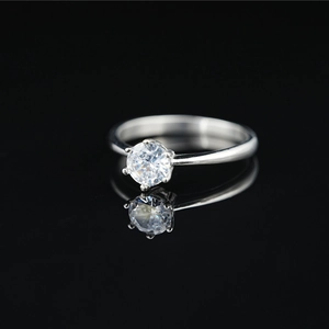Minimalist titanium steel moissanite ring with six-prong setting on black mirror background