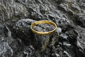 Detailed macro shot of golden minimalist bangle featuring a unique hammered texture finish