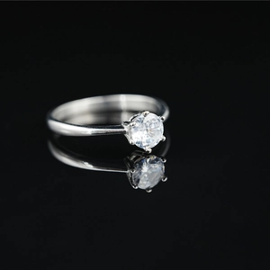 Minimalist titanium steel moissanite ring with six-prong setting on black surface
