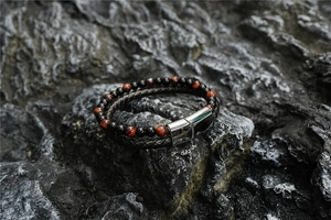 Detail of red tiger eye beads and double-layer woven leather bracelet with magnetic clasp