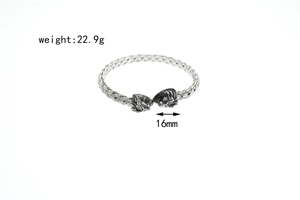 Detail of silver viking lion head bangle with braided metal texture and dimensions