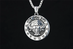 Detail of vintage steel zodiac ox pendant with traditional Chinese characters and bead chain