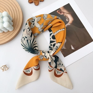 Close-up of floral lily print silk scarf with fine stitching and elegant yellow tones