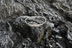 Close-up of silver titanium steel bangle showing brushed metal texture and hinge clasp