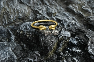 Vue détaillée de deux bracelets câbles en acier titane bicolore avec têtes de léopard