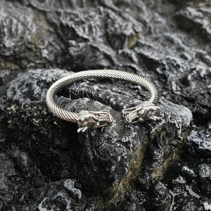 Brazalete de acero inoxidable para hombre con cabeza de dragón sobre fondo de piedra