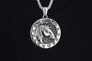 Macro detail of silver stainless steel zodiac pendant with horse relief and engraving