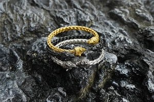 Detailed close-up of woven stainless steel wolf head bracelets in gold black and silver