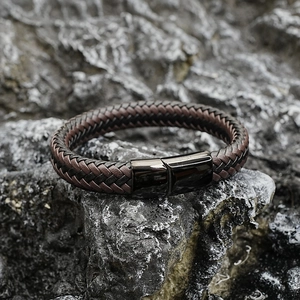 Bracelet en cuir tressé avec fermoir magnétique noir sur un fond en pierre gris foncé