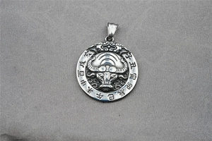 Detail of titanium steel round pendant with relief ox and Chinese zodiac engravings