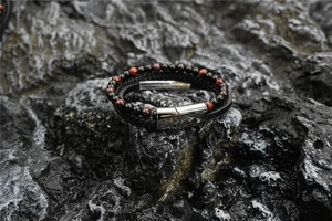 Detail of double-layer men's bracelet with tiger eye beads and braided leather cord