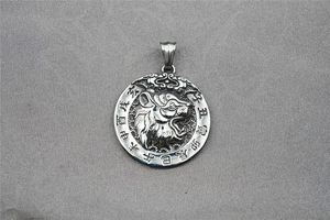 Detailed close-up of tiger zodiac relief on vintage stainless steel pendant necklace
