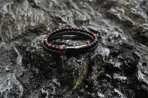 Close-up of double-layer bracelet with tiger eye beads and black braided leather cord