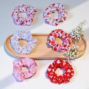 Set of 6 Valentine's Day scrunchies with pink hearts and LOVE patterns on wooden tray