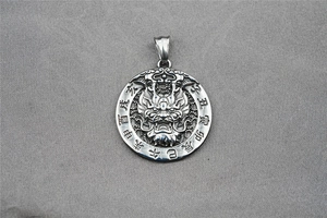 Macro detail of silver dragon pendant with engraved zodiac symbols and vintage texture
