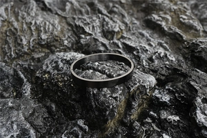 Macro detail of black matte brushed stainless steel bracelet with a sturdy hinge closure