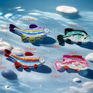 Colorful fish-shaped acetate hair claw clips displayed on water with ripple effects
