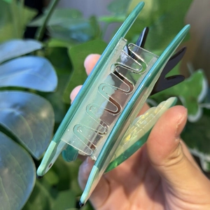 Detail of green translucent swallow hair claw clip with internal metal spring mechanism