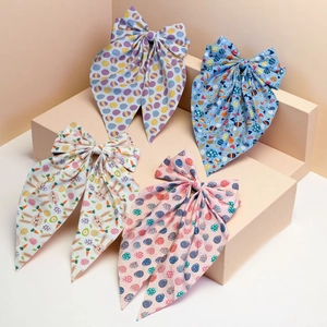 Detail of four Easter bunny and egg pattern bow hair clips in pastel colors on steps