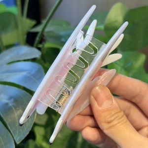 Detail view of swallow claw clip with white acrylic design and durable metal spring